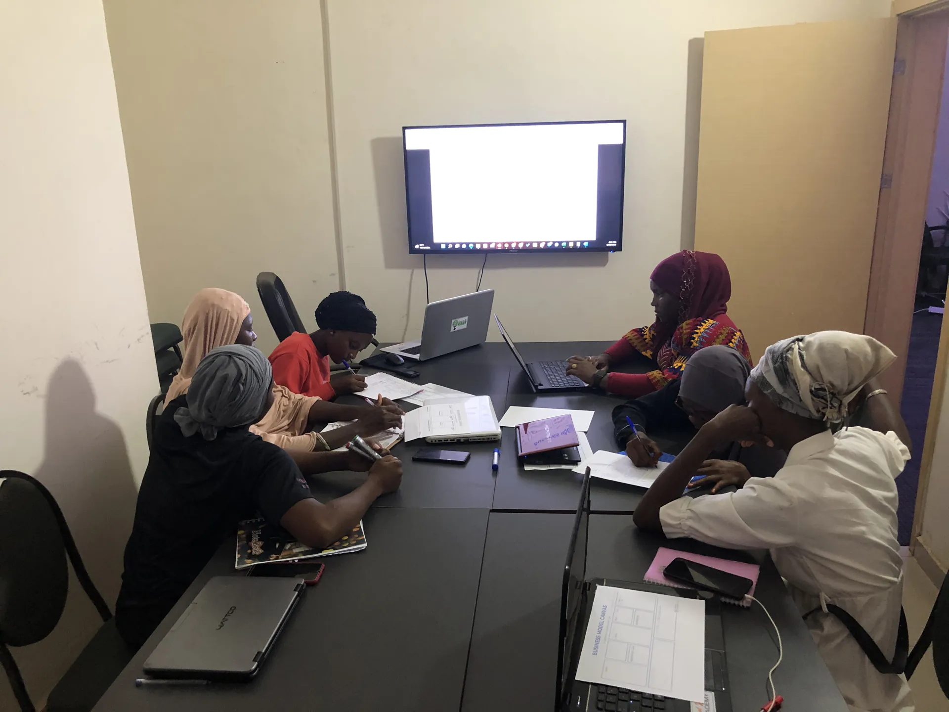 Participants et ordinateurs réunis autour d’une table de formation
