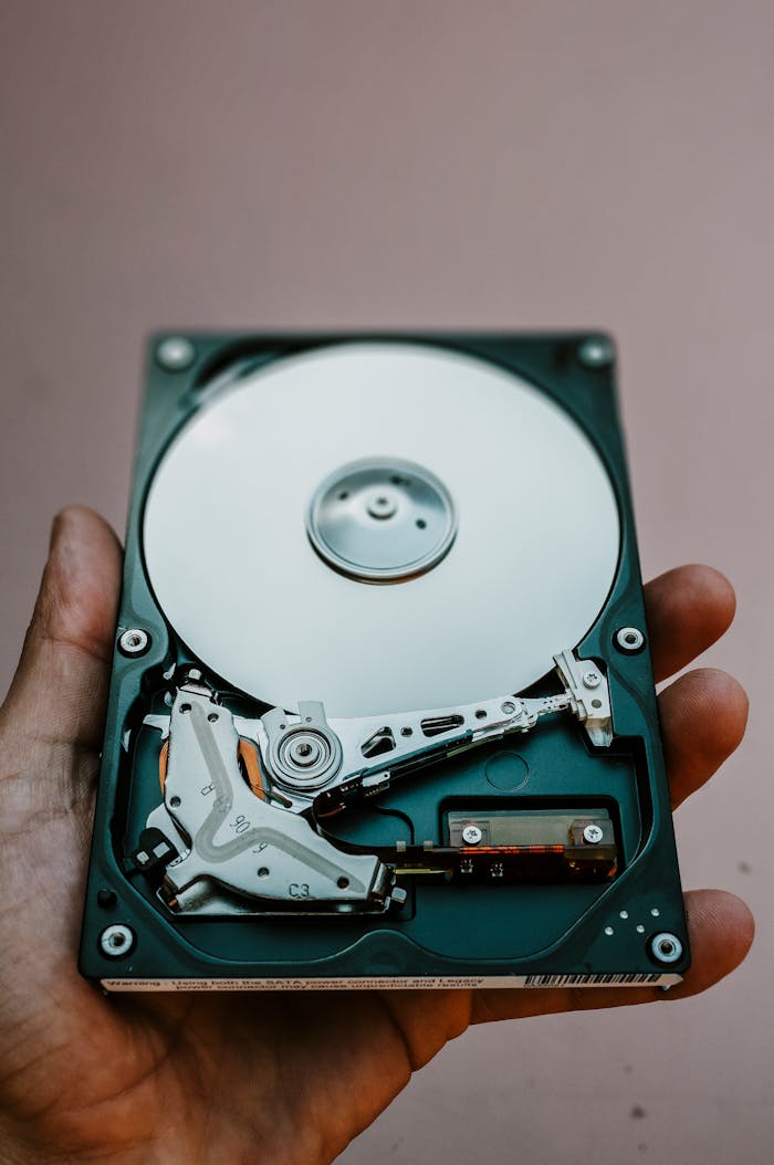 Close-up view of an open hard drive held in a hand, illustrating data storage technology.